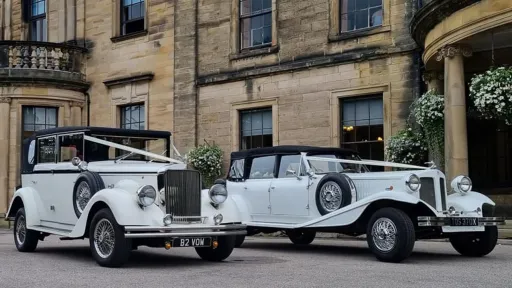 Paif of White vintage Wedding Car decorated in front of Bristol Wedding Venue