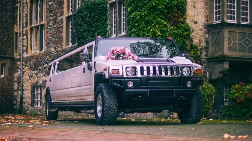 16-seater Stretched Hummer Limousine with Chrime grill and decorated with pink wedding flowers on the bonnet