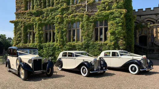 Two Black & Ivory Classic Cars and One Vintage Car displayed in front of a wedding venue in Scottish Highlands