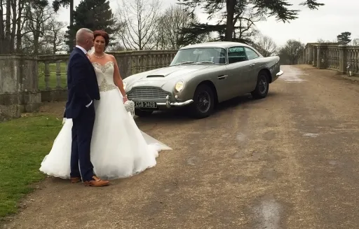 Classic Aston Martin DB5 hired for a Norfolk wedding with Bride and Groom next to the car