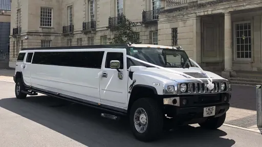 White Stretched Hummer Limousine dressed with white Wedding Ribbons at the front