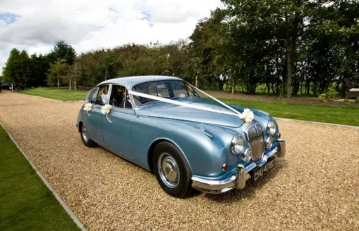 Silver Blue Classic Daimler in Bedfordshire  dressed with white ribbons and a small bow on top of the chrome grill