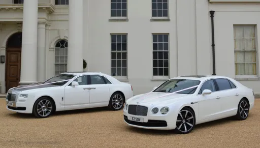 Two Modern Cars in wedding duties in Surrey. Car on the left is a Rolls-Royce Ghost Series 2 in white with Silver Bonnet and the second vehicle on the right is a White bentley Flyi