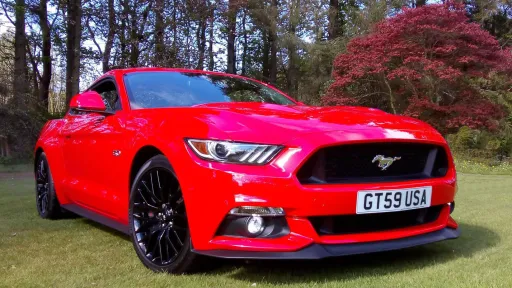 Rear front view of Red Mustang in a Lancashire Park. Black Alloy wheels and the Mustang Logo on the front grill