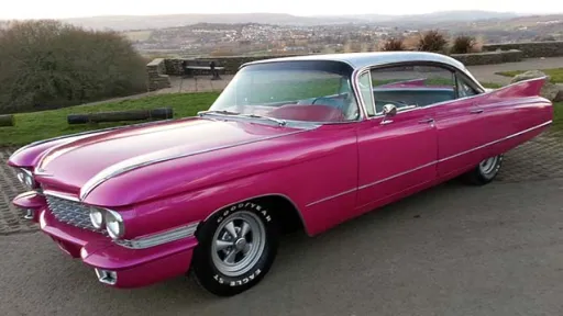 Classic Pink American wedding car with white roof with Gloucestershie country side in background