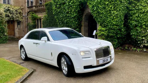 Modern White Rolls-Royce Ghost in front of wedding venue