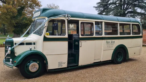 Classic Bedford bus on wedding duties in Berkshire. Bus is in two-tone Cream and green and decorated with white ribbons.