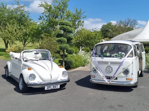 Classic Vw Campervan and Beelte in front of wedding venue in Warwickshire. Both vehicles decorated with ribbons