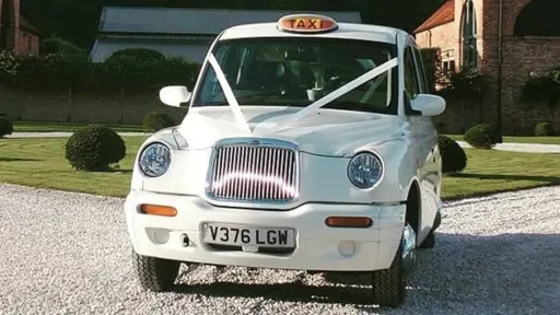 White Modern Taxi Cab dressed with white ribbons accross its bonner