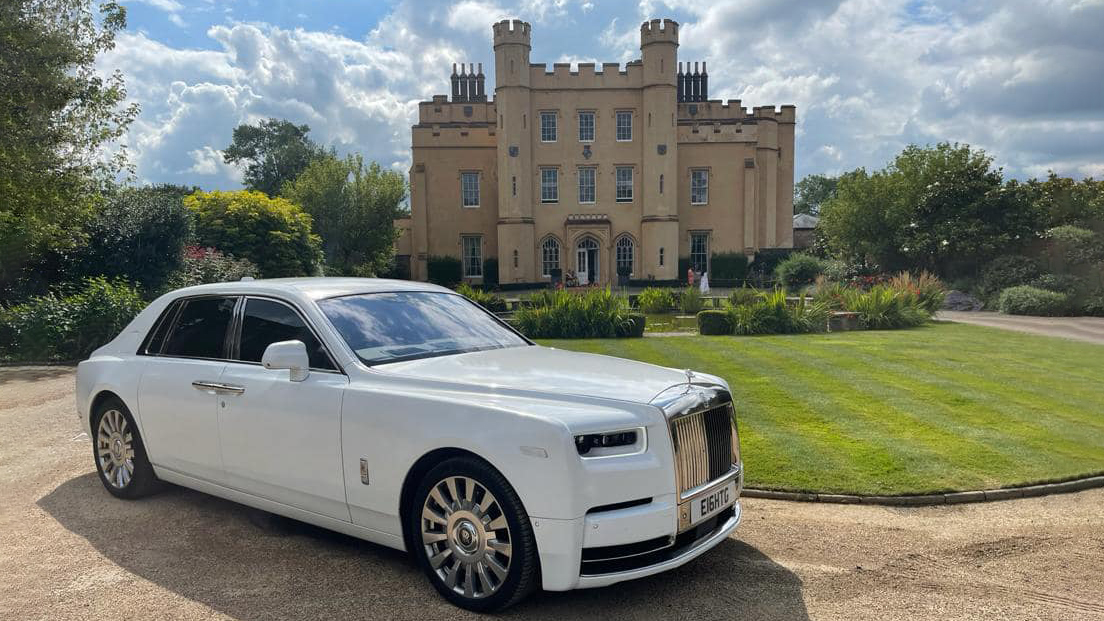 White Rolls-Royce Phantom 8 with its large chrome alloy wheels in attendance at a popular wedding venue in Aylesford. Castle style building in the background.