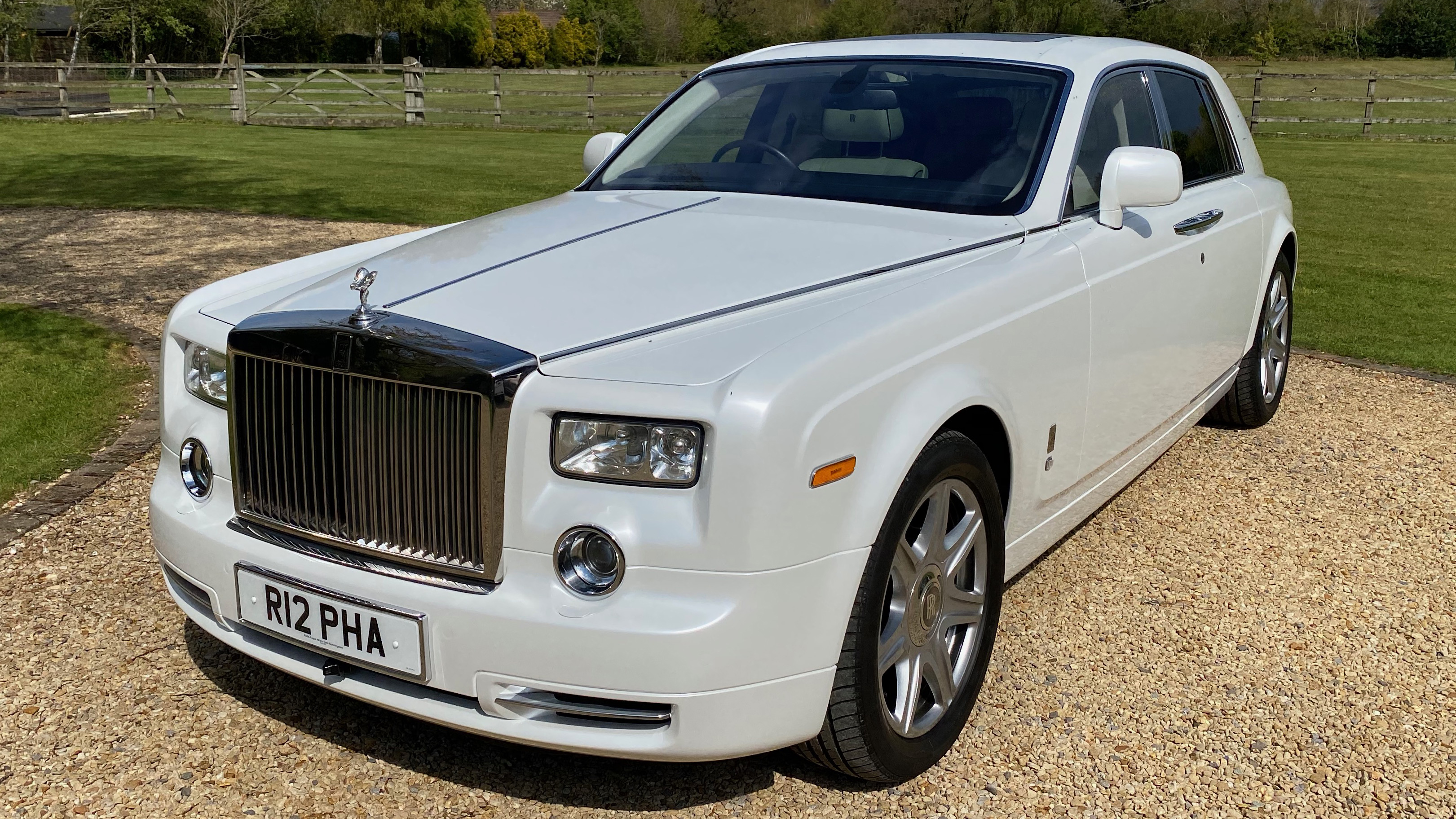 Front view of White Modern Rolls-Royce Phantom showing its iconic large chrome grill with spirit of Ecstasy mascot on top.