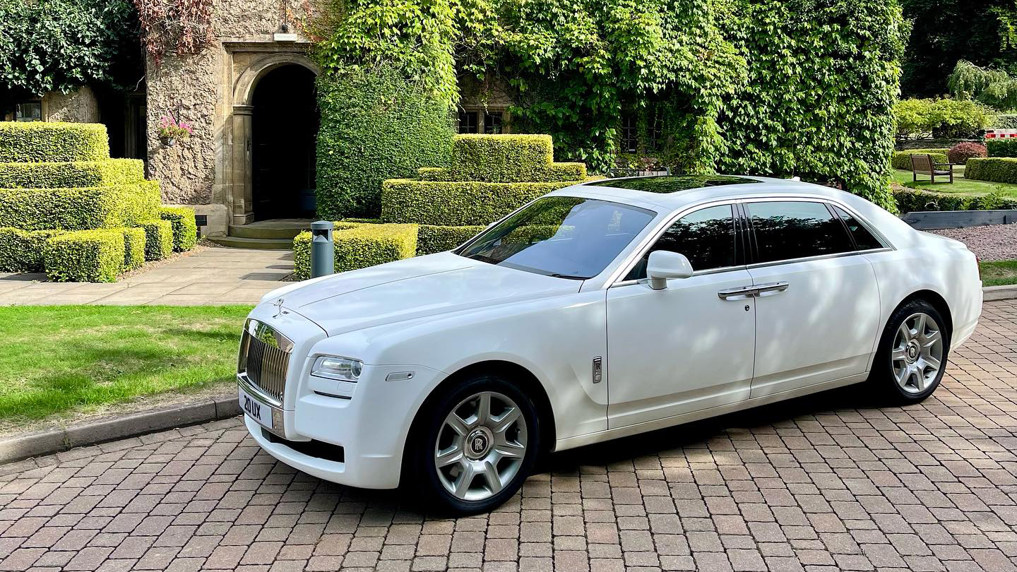 White Rolls-Royce Ghost parked in front of a wedding venue in Syston. Car has blacked out windowsome wheels and sunroof.