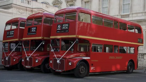 Fleet of Vintage Red Routemaster Bus white White Ribbons in attendance to a wedding in Bedfordshire