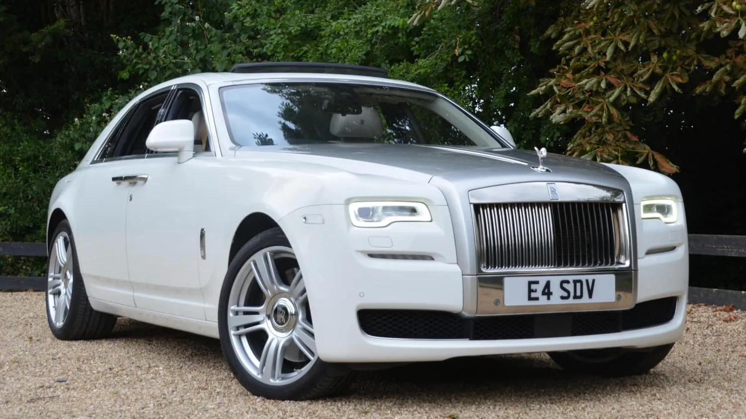 Modern white Rolls-Royce Phantom with its large chrome alloy wheels and iconic chrome front grill in attendance at a popular wedding venue in Colchester in Essex.