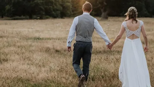 Bride and Groom Walking and holding hands in the New Forest, Hampshire.