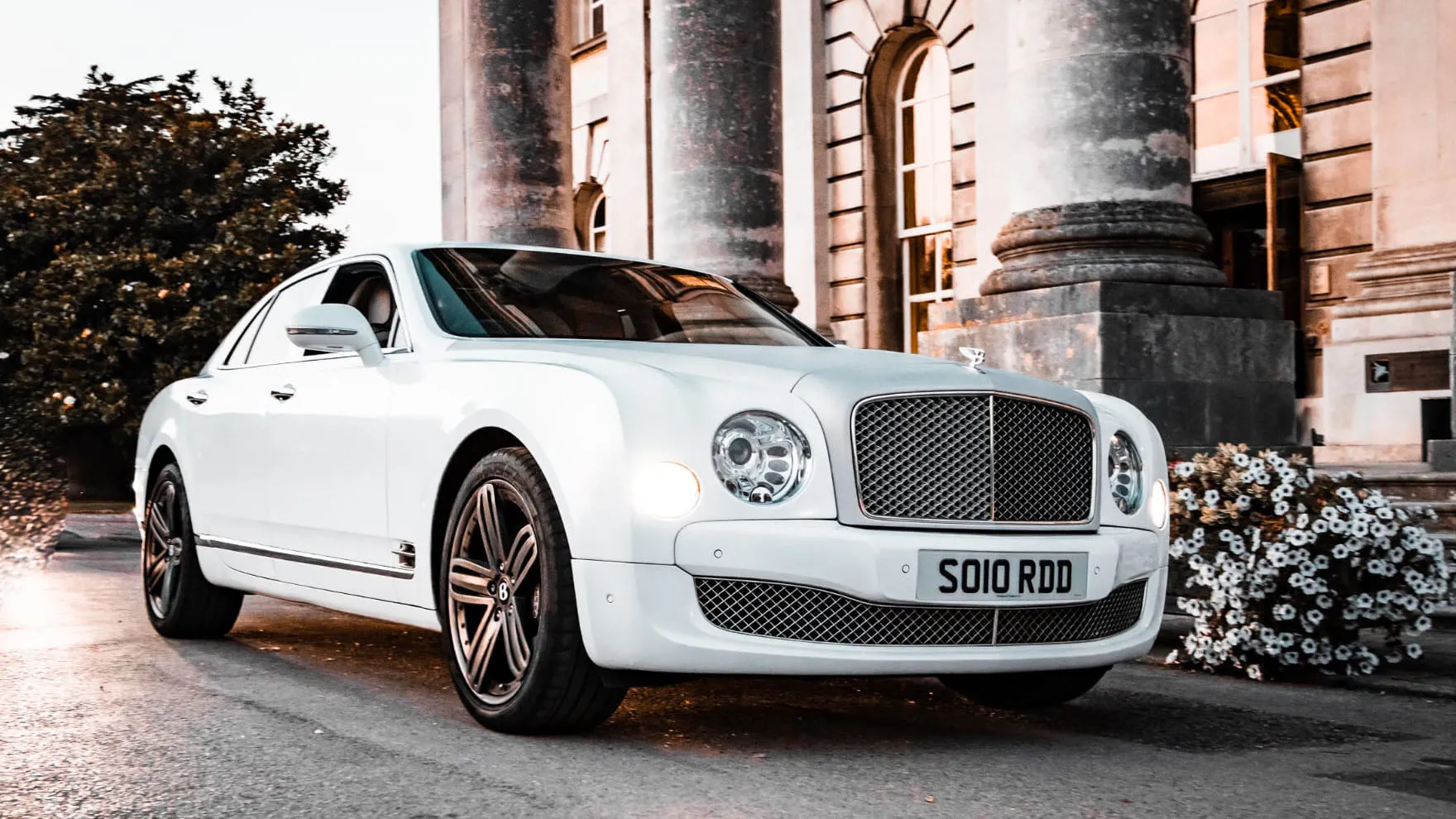 Side View of Luxurious & Modern White Bentley Mulsanne in Front of Wedding Venue