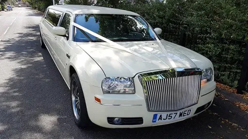 Front view of White stretched limousine with white ribbons and chrome front grill