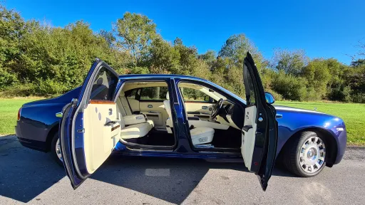 Modern Blue Rolls-Royce Ghost with doors open showing cream leather interior at a Golf Club in Wiltshire