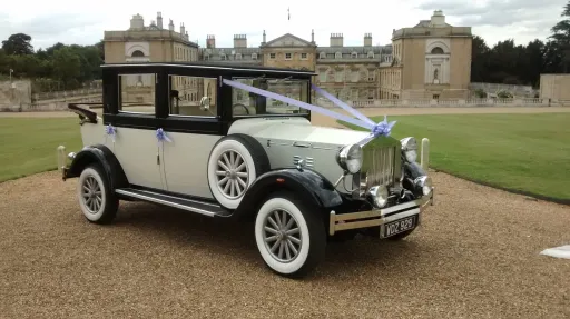 Black & Ivory 6-seater Vintage Imperial Convertible decorated with White Ribbons at a venue in Wiltshire