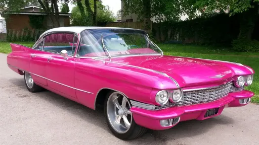 Pink American Cadillac with white roof waiting for Bridal party in Carmarthenshire