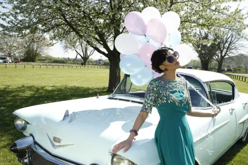 Bride with a Green Dress standing on an American Cadillac.