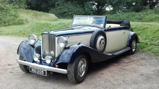 Convertible vintage car in Blue and Cream and spare wheel mounted on side