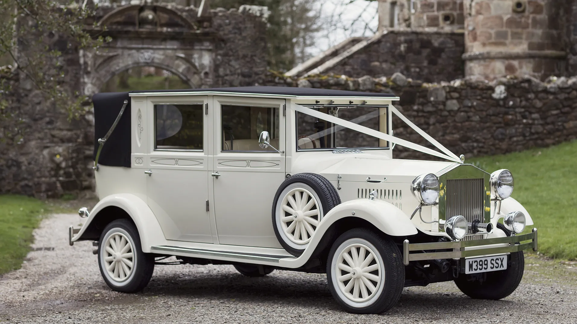 Vintage Imperial decorated with white ribbons parked in front of a popular wedding venue in Ayr