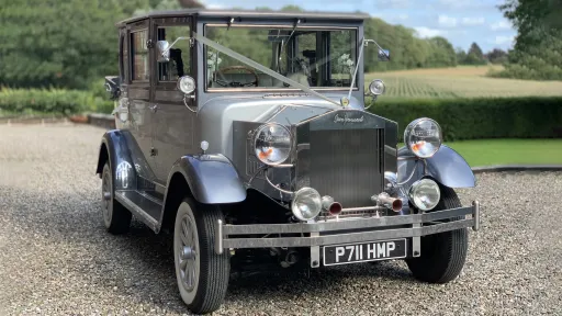 Silver Vintage imperial wedidng car with white wall tires and silver ribbons on front bonnet