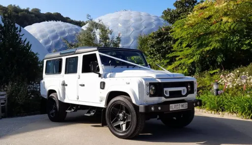 White Landrover wedding car with White ribbons and black wheels