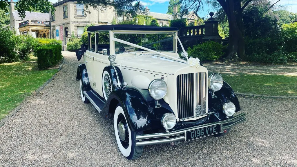 Vintage Regent Limousine outside wedding venue dressed with White Ribbon and White Bow.