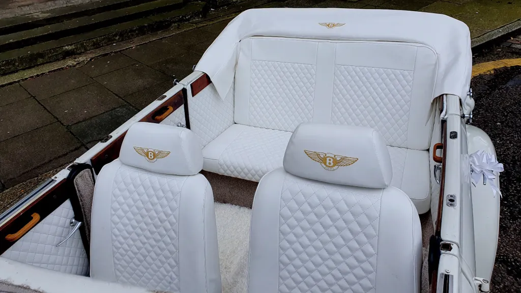Aerial viw of Beauford interior showing White Leather with Gold coloured Bentley logo on headrests