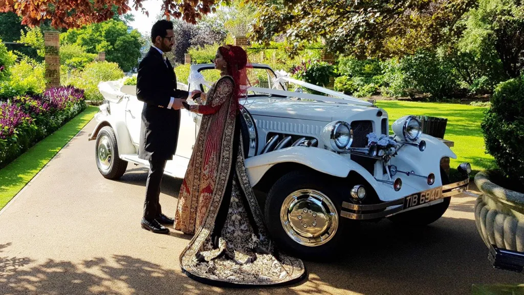 Couple posing for photos in front of Beauford in Richmong Park in London. Bride is wearing a Traditional Red Asian Weding Dress