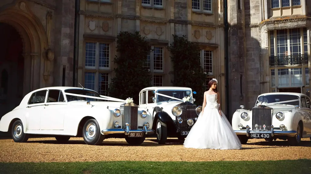 Wedding cars in front of wedding venue with Bride standing in the middle