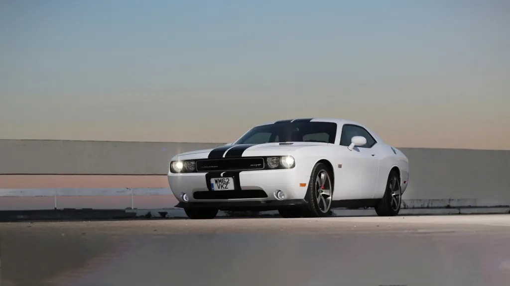 White american Dodge Car with two black stripes accross the front of the vehicle