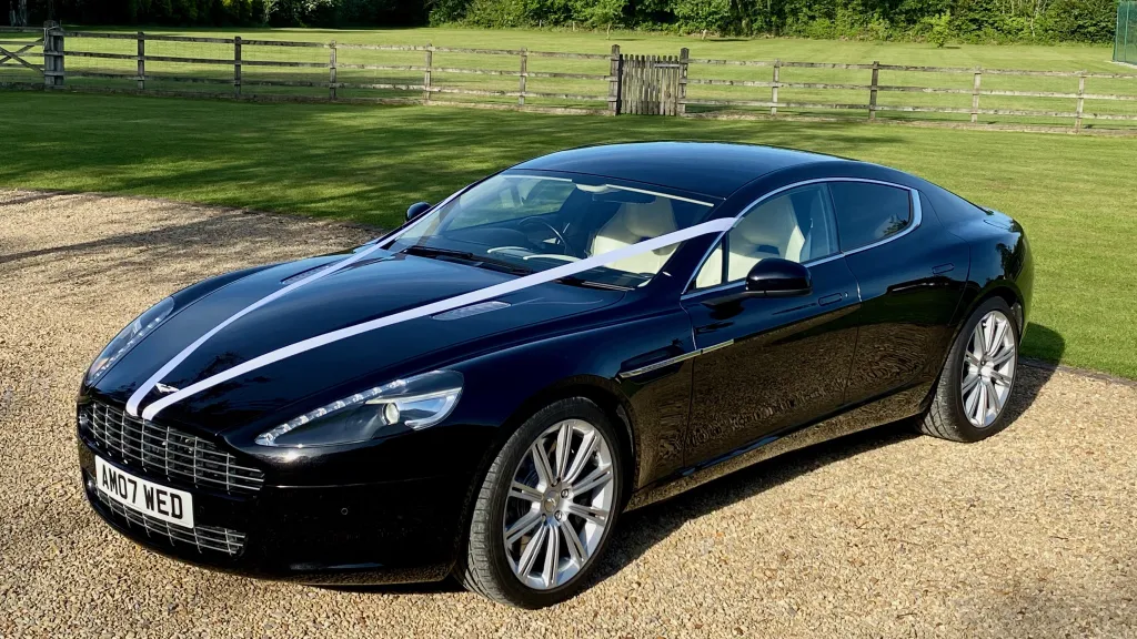 Modern Black 4-Doors Aston Martin Rapide dressed with White ribbons