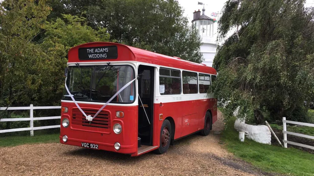 Classic White & Red Single Decker Bristol Bus with White Wedding Ribbons entering venue