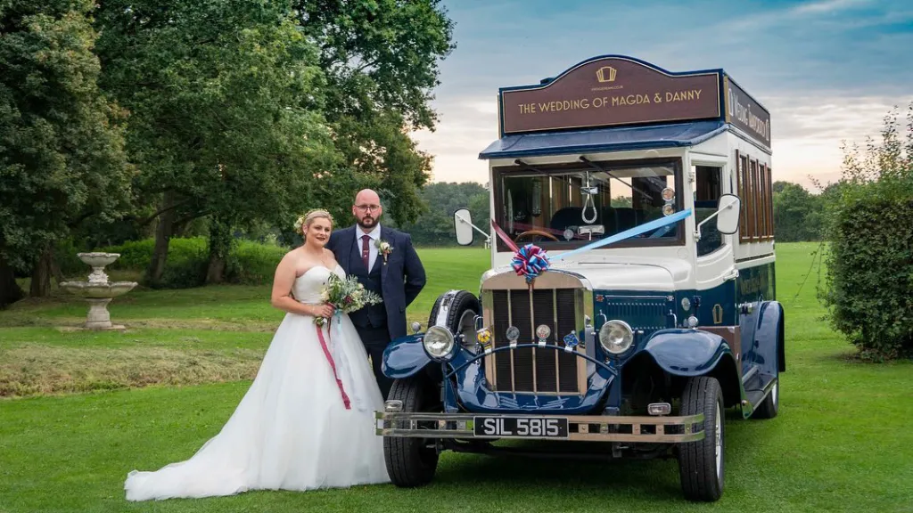 Vintage Asquith Bus with Bride and Groom next to the vehicle