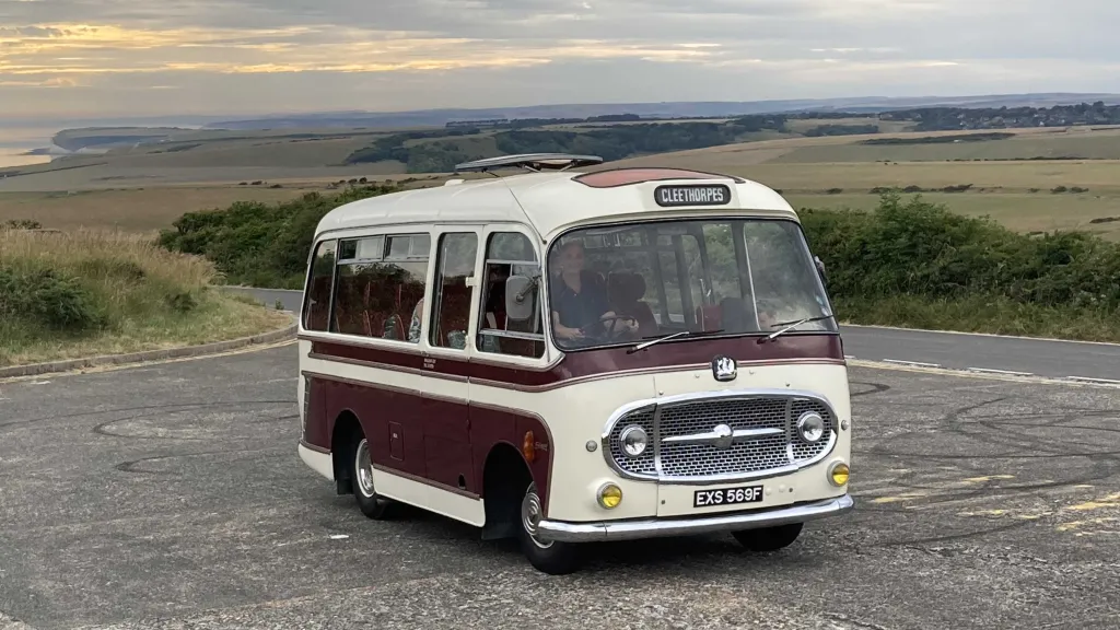 Single Decker White & Burgundy Bedford Bus with Driven behind the steering wheel