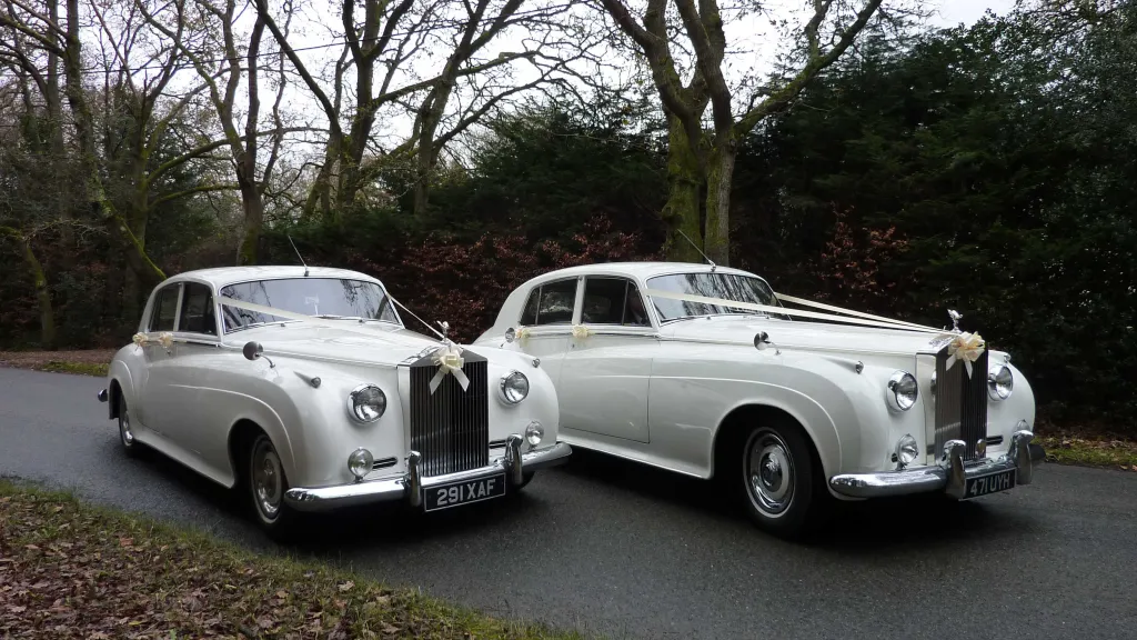 Two Matching Classic Rolls-Royce Silver Clouds with traditional White ribbons on Bonnet
