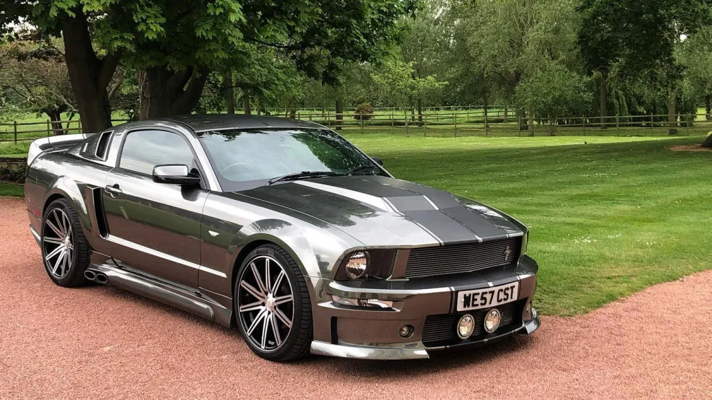 Grey with black stripes Modern Ford Mustang in a Park