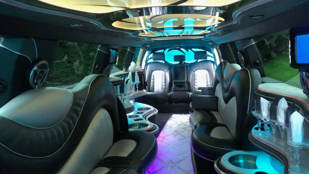 Inside of Audi Limousine showing large Black & Silver Leather Bench Seat, Cocktail Bar and Ambient Lighting