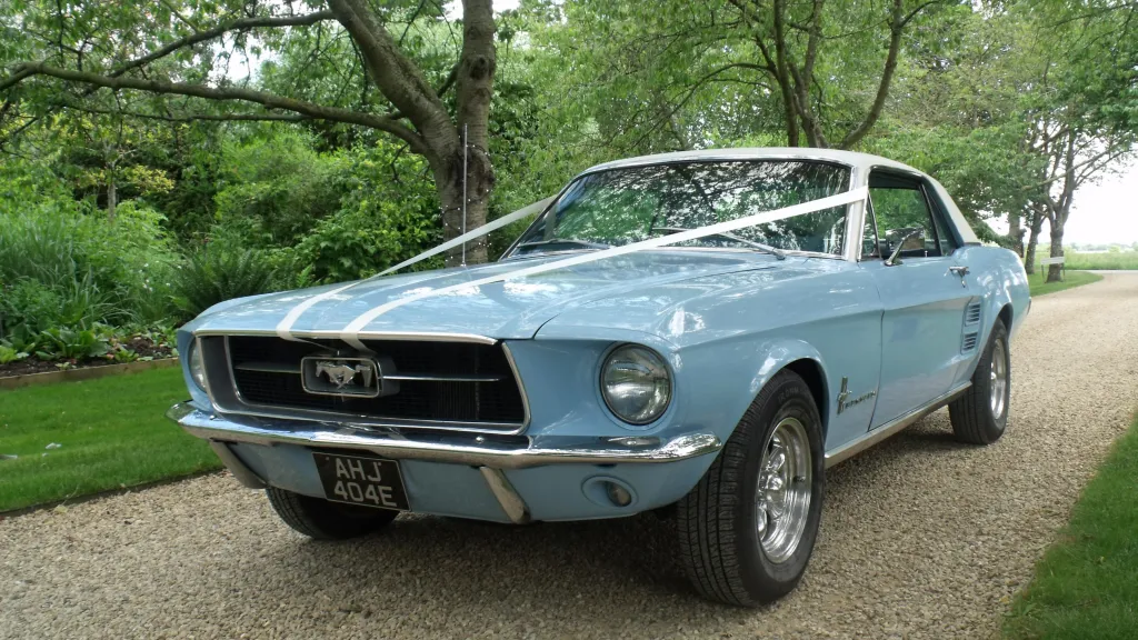 Classic Ford Mustang in light blue with white ribbons