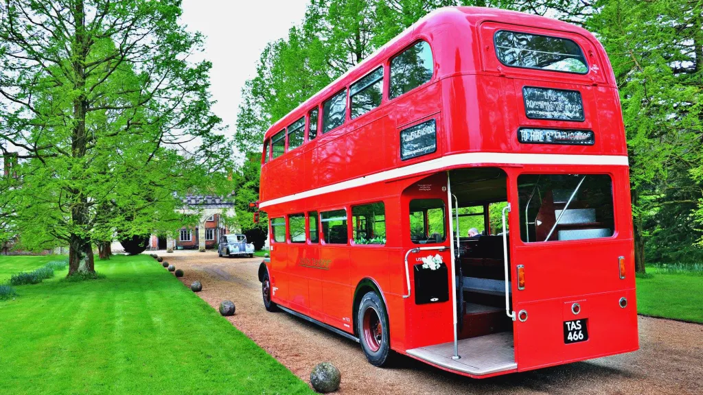Rear View of the open platform in a Red Routemaster London Bus entering wedding venue.