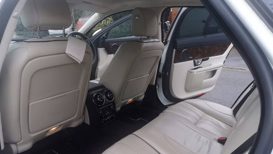 Rear interior with cream leather interior showing the dark wood on the doors