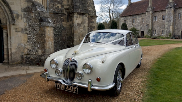 Front view of a Classic Mk2 Jaguar in front of Church in Reading. Car is decorated with White Ribbons accross the front bonnet