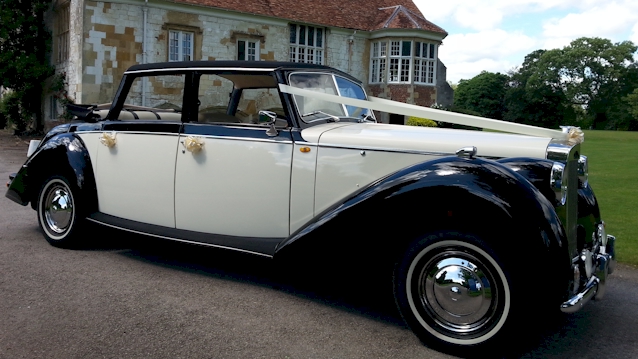 side view of a Black & White Royale with the roof open decorated with Ivory ribbons
