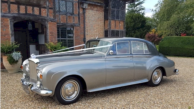 Left side view of Classic Bentley S3 in two-tone silver decorated with white ribbons