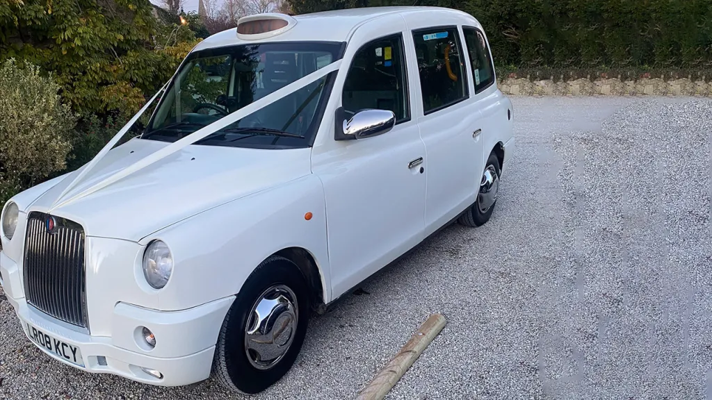Modern White Taxi Cab with White Ribbons across its bonnet