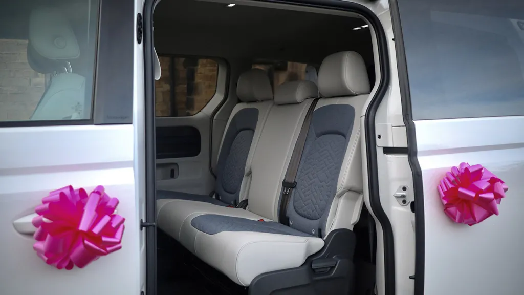 Inside rear seating showing forward facing 3 passenger seats equipped with seat belts