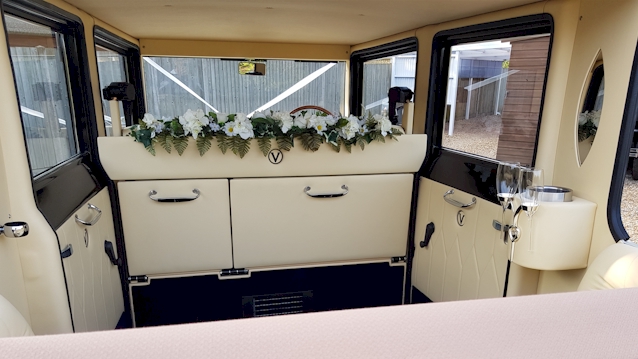 Rear inside of Imperial Viscount wedding car with cream leather inerior and seats with floral decoration inside the vehicle